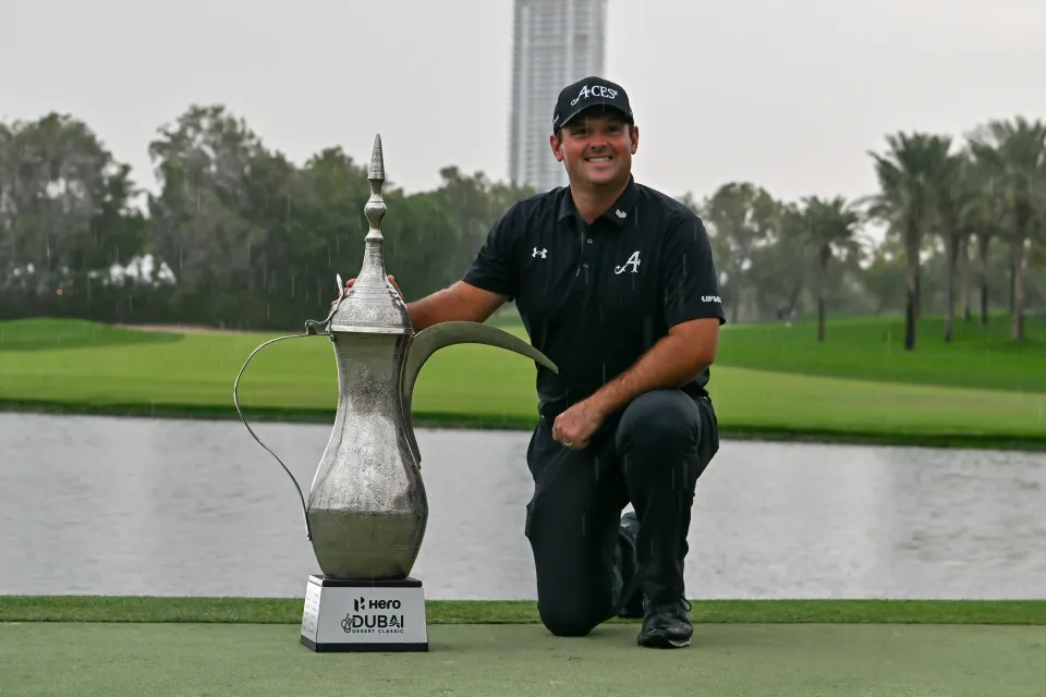American golfer Patrick Reed wins the trophy after competing against Spanish golfer David Puig (not seen) in the fourth and final round of the Hero Dubai Desert Classic 2026 at Emirates Golf Club in Dubai, United Arab Emirates on January 25, 2026.