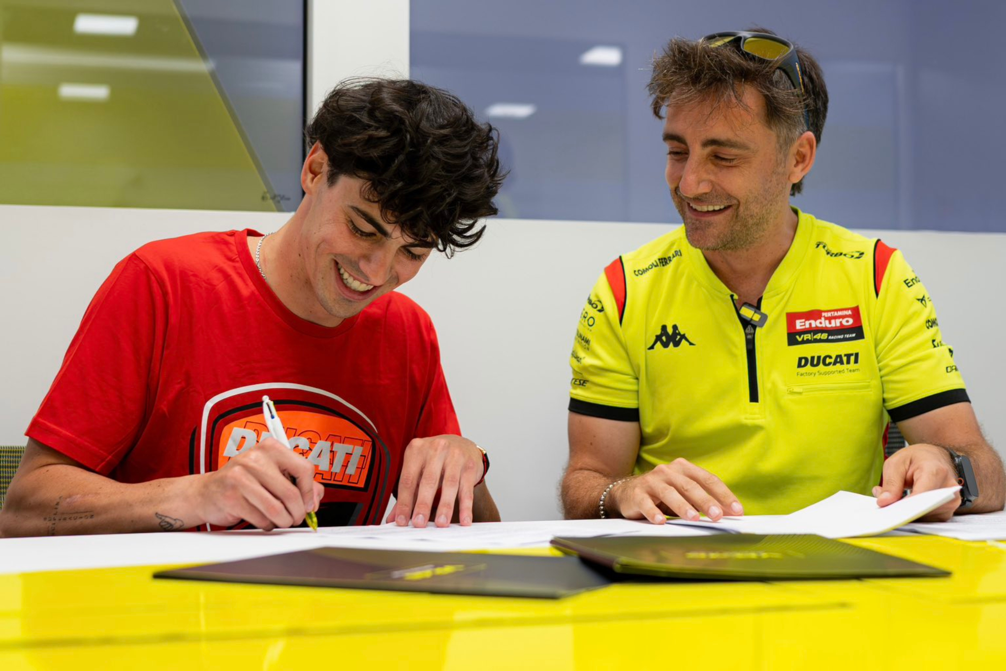 Aldeguer firmando su contrato con el VR46, con Pablo Nieto a su lado.