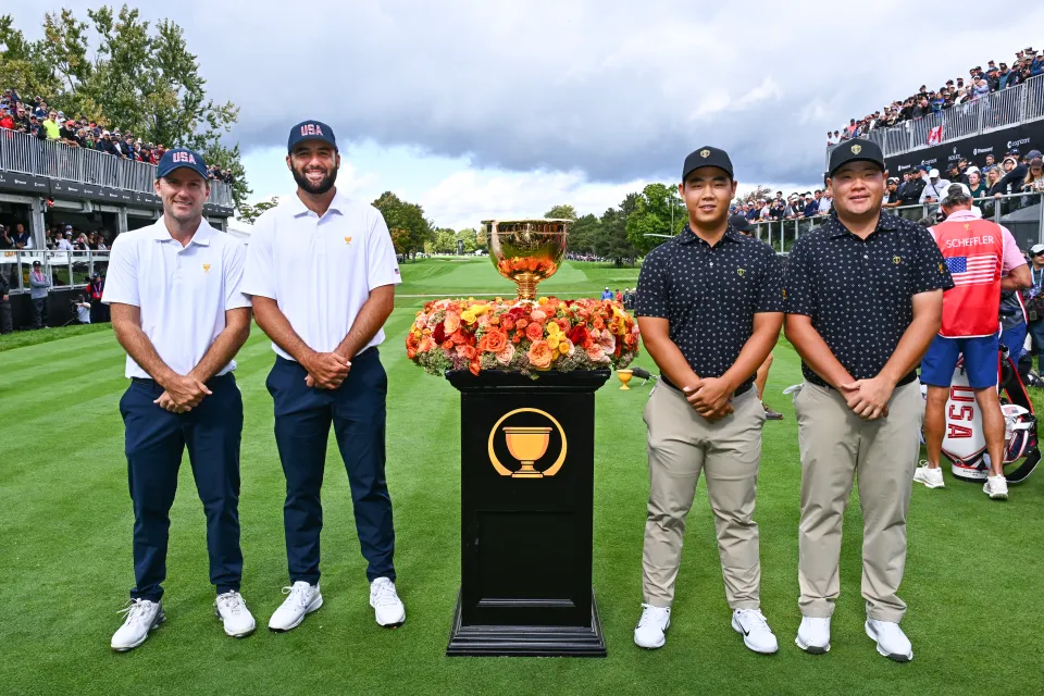 Russell Henley of the U.S. Team, Scottie Scheffler of the U.S. Team pose with Tom Kim of the International Team and Sungjae Im of the the International Team and the Presidents Cup trophy on the first tee during Four-Ball on day one of the 2024 Presidents Cup