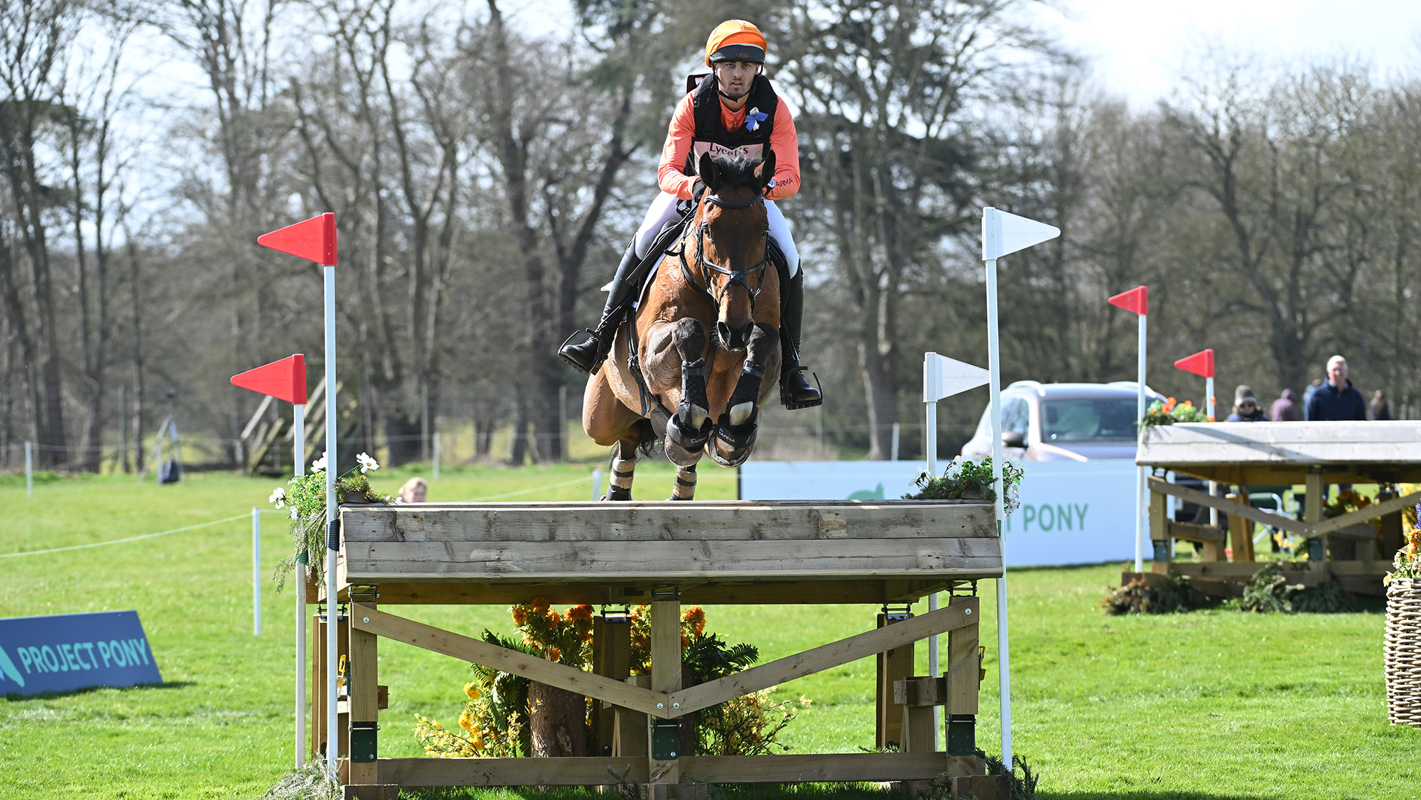 Tom Woodward, a rider in orange colours, rides bay horse Low Moor Lucky over a table fence at Thoresby 2025