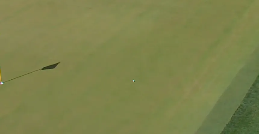 Corey Conners' ball on the green after a fan kicked it