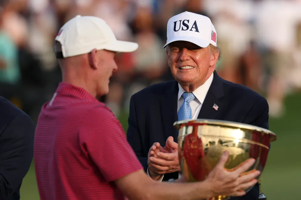 Captain Brandt Snedeker of the U.S. Team is presented the trophy by the U.S. President Donald Trump after their 17-13 win during the trophy ceremony following the Sunday's Singles on day four of the Presidents Cup 2026 at Medinah Country Club on September 27, 2026 in Medinah, Illinois.